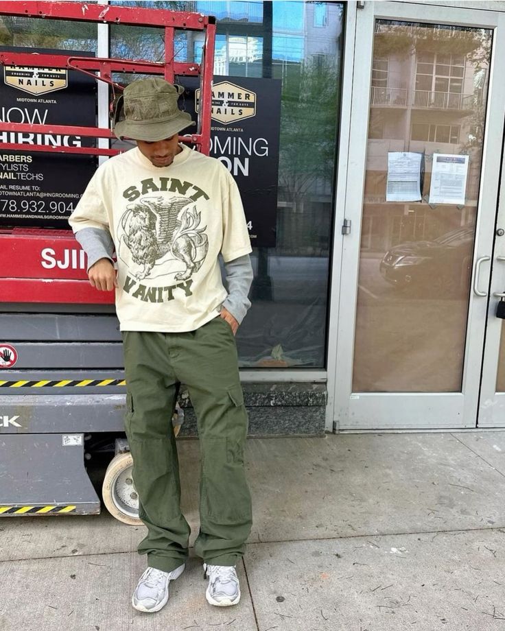 Cream graphic tee over long-sleeve gray shirt, green cargo pants